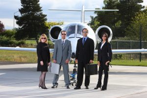 Group of business people with corporate jet in background